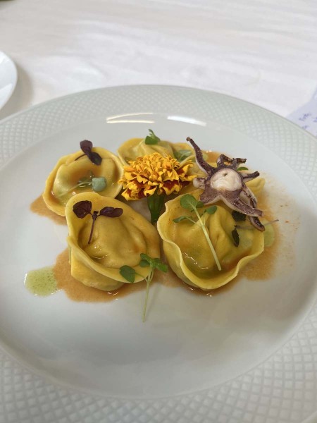 Piatto di tortelli gourmet decorato con fiori ed erbe