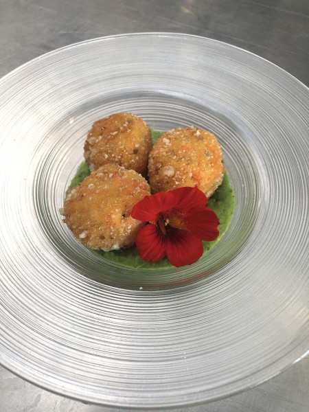 Piatto di crocchette gourmet con decorazione floreale